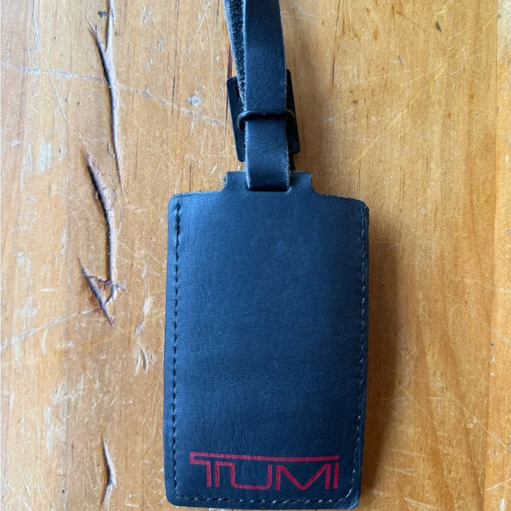 Tumi Black Leather Luggage Tag with Black Buckle And Red Lettering